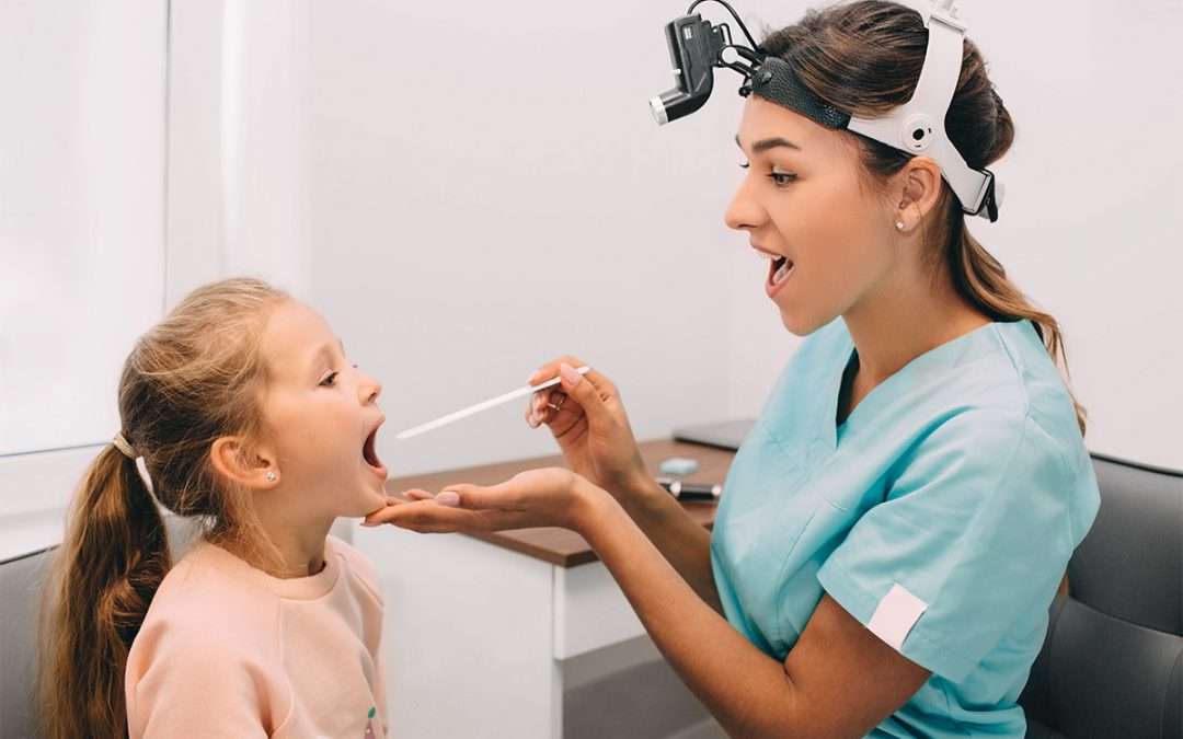 Little girl being examined by an ENT doctor for tonsillitis