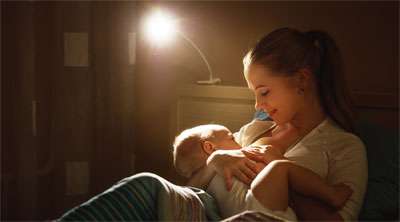 Mom Breastfeeding Baby at Night Before Bed