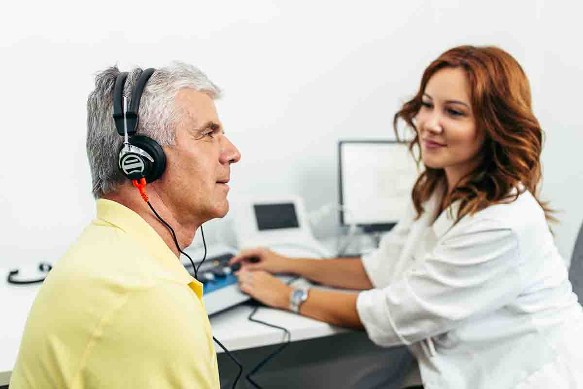 Older man undergoing a hearing test with his audiologist