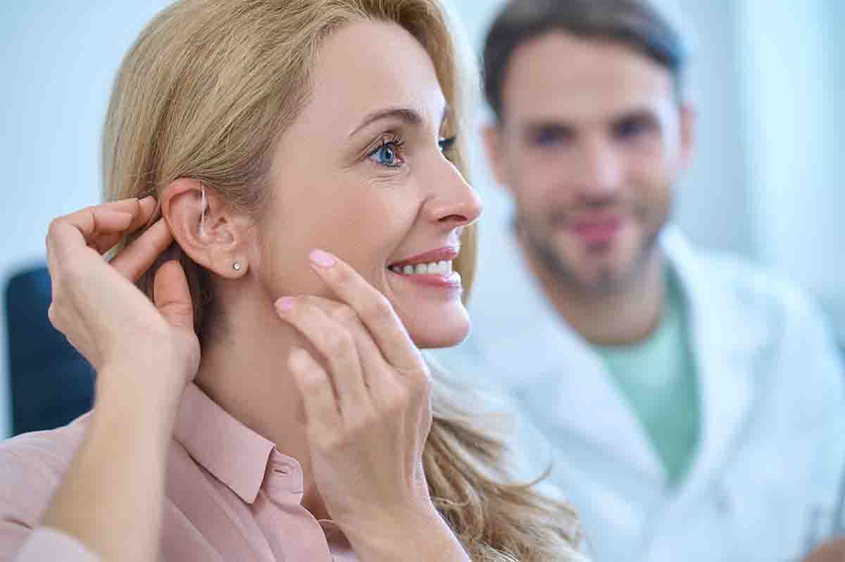 Older woman being fitted with an over the ear hearing aid