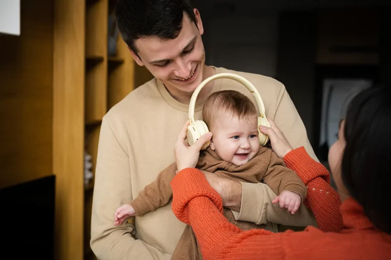 woman and man holding child wearing protective headphones
