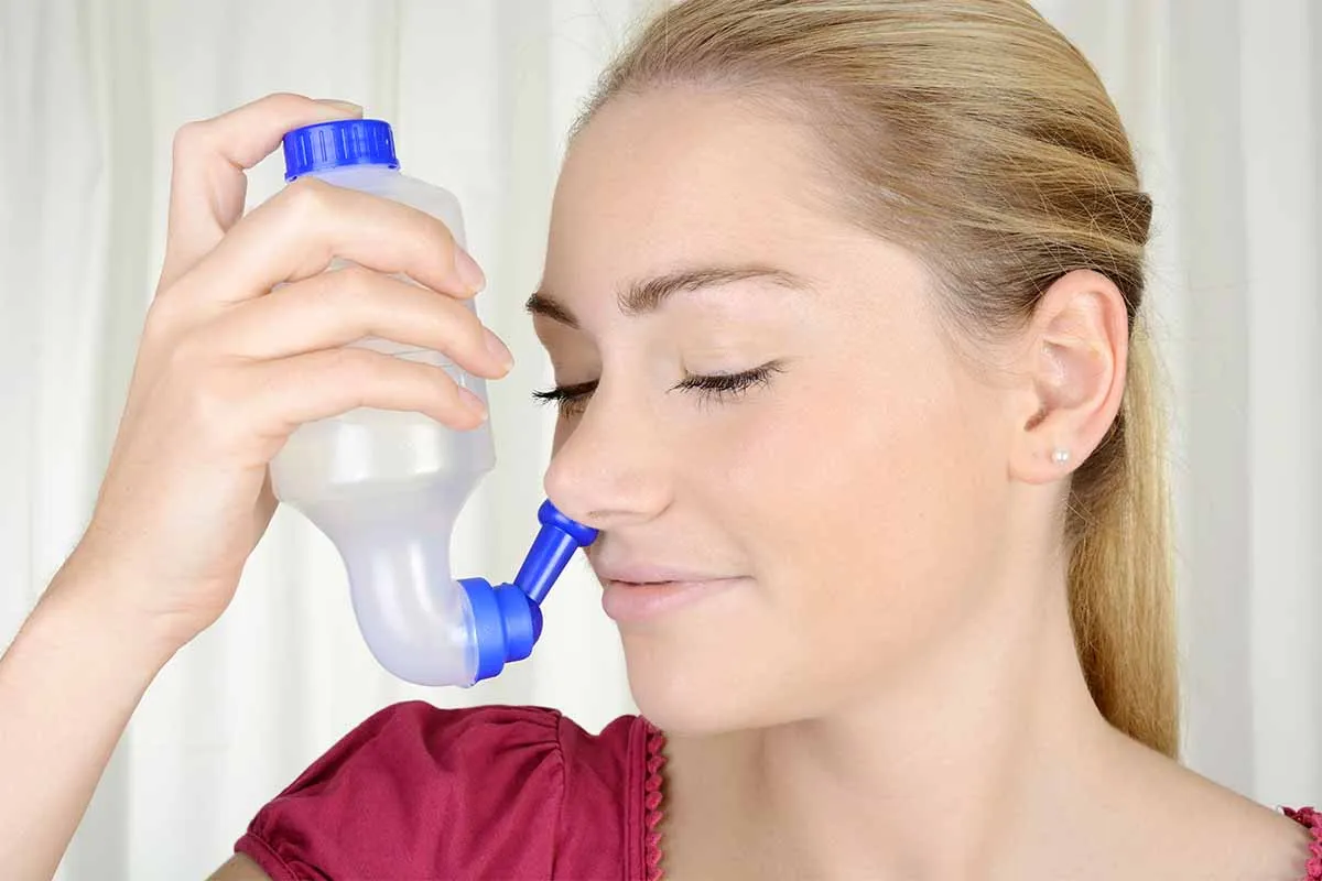woman using a nasal rinse to manage nasal dryness